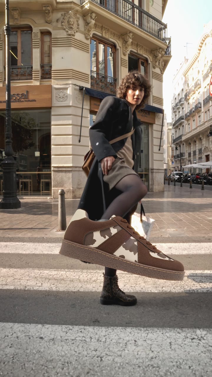 Model mit Stiefel vor einer Stadtkulisse